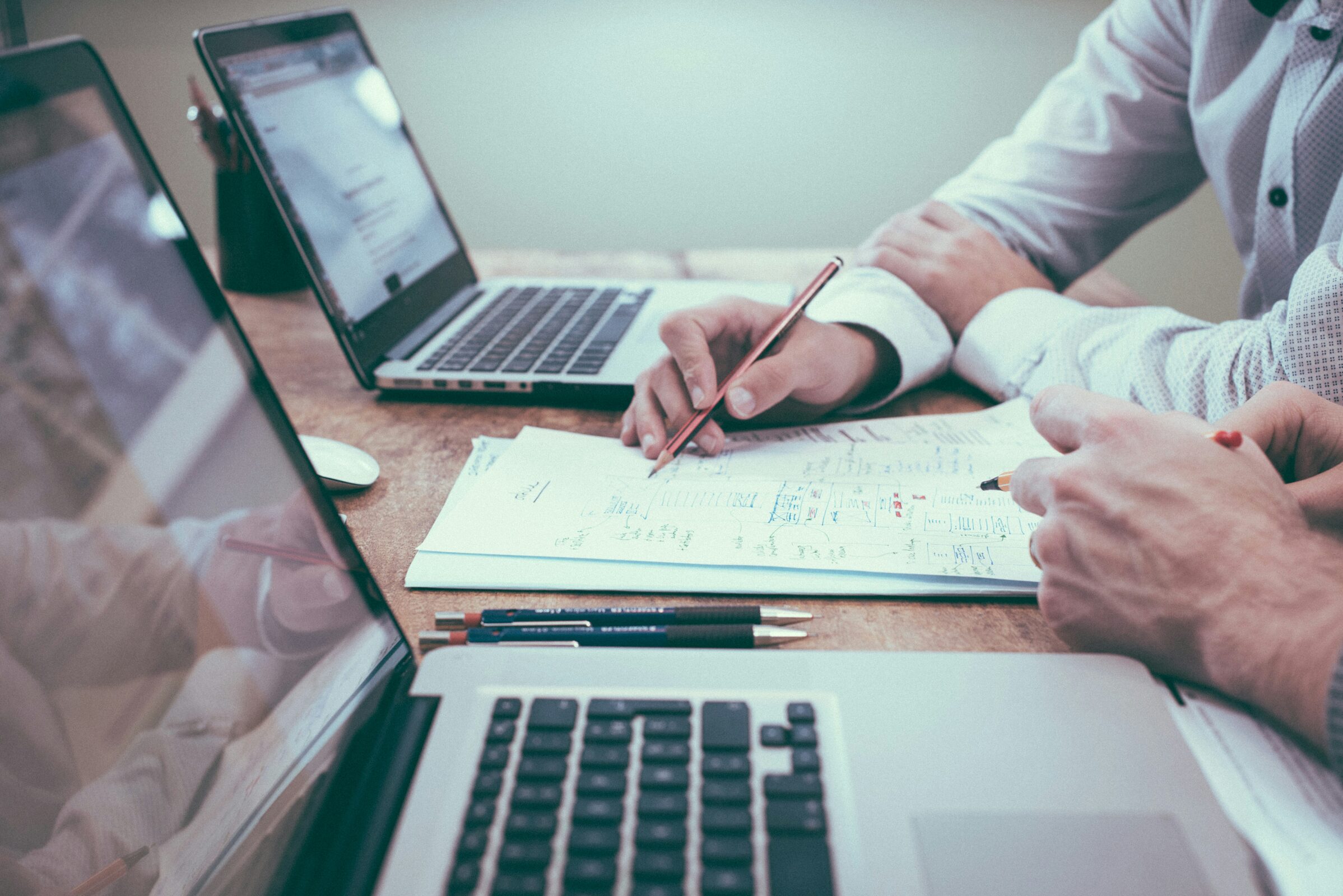 Two colleagues in conversation across a desk. Photo by Scott Graham on Unsplash.